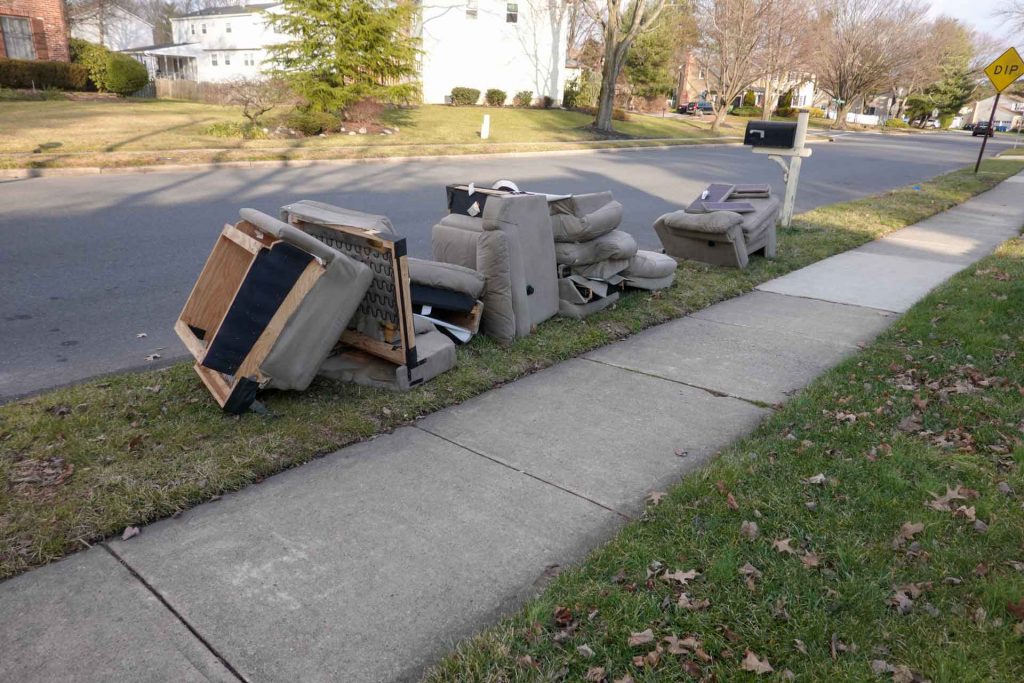 Old grey armchairs disassembled by road